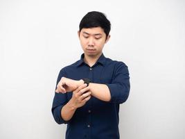 gesto de hombre asiático mirando su reloj emoción seria fondo blanco foto