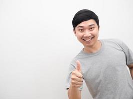 hombre camisa gris sonriendo y pulgar arriba blanco aislado foto