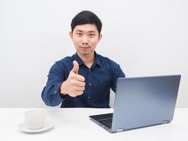 Man confident show thumb up with his laptop on the table photo
