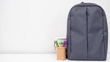 mochila escolar con caja de lápices y libros en el escritorio espacio de copia de fondo blanco foto