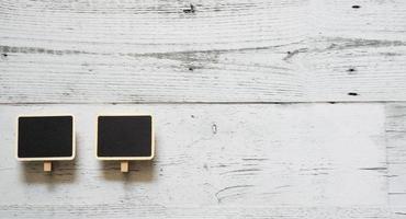 dos pequeños clips de pizarra línea de matriz de marco de madera en la mesa de madera blanca espacio de sombra de la naturaleza, concepto de pizarra de aviso de idea foto