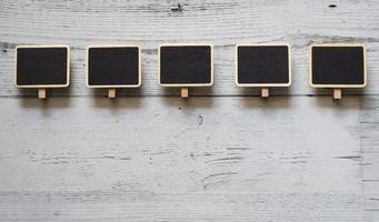 Five small clip chalkboard array line on white wood table nature shadow below space,Idea signboard concept photo