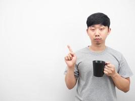 Man sleepy emotion holding coffee cup point finger at copy space photo