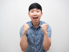el gesto de la camisa azul del hombre asiático satisface la emoción feliz y el retrato del puño foto