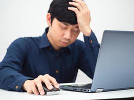 Man working from home with laptop on the table and feeling strian touch his head photo