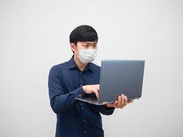 Man with protect mask using laptop with sreious face on white background photo