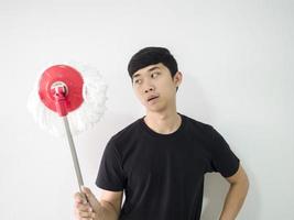 Asian man feel bored at face looking mop in hand on white isolate background half body photo