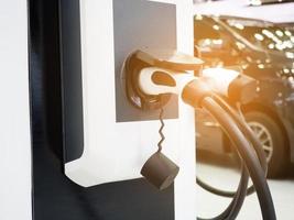 enchufe del vehículo de carga eléctrica para recargar la batería del automóvil energía de energía limpia para el concepto futuro con destello de luz foto