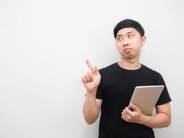 Man holding tablet feeling bored and point finger at copy space photo