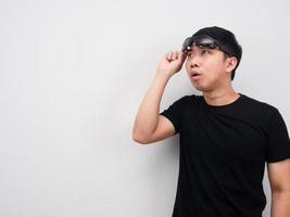 Asian man take off his sunglasses for looking at copy space feeling excited photo