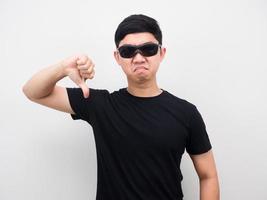 hombre con gafas de sol cara enojada mostrar el pulgar hacia abajo fondo blanco foto