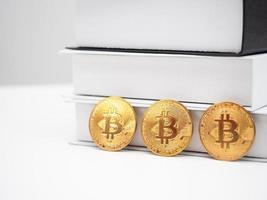 Three golden bit coin at the book on table the digital money crypto photo