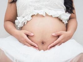 Closeup beautiful belly of pregnant woman white background photo