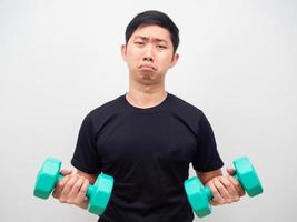Man holding drumbbell feeling bored to workout sad emotion