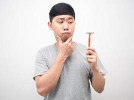 Man touch feeling doubt and looking at shaving in hand photo