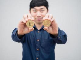 Closeup gold bitcoin in man hand smile face white background portrait photo