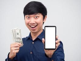 hombre asiático cara feliz y sonrisa sosteniendo dinero y mostrar retrato de pantalla blanca de teléfono móvil foto