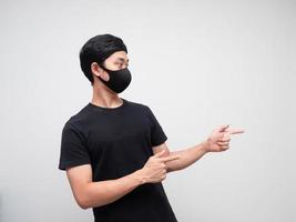 Portrait man wearing mask double point finger and looking at right side on white background photo