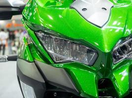 Closeup front light of motorcycle sport green color photo