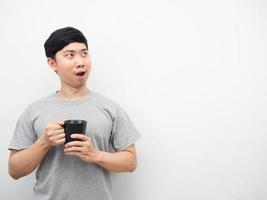 Man holding coffee cup feeling excited looking at copy space photo