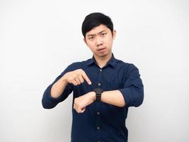 el hombre asiático señala con el dedo su reloj mirándote emoción seria concepto de prisa foto