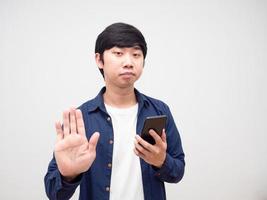 Man feeling bored and holding mobile phone show hand stop white isolated photo