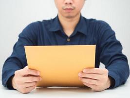 hombre sentado y leyendo el sobre del documento en la mesa foto