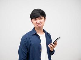 Asian man holding cell phone in hand with bored face and not not satisfied white background photo