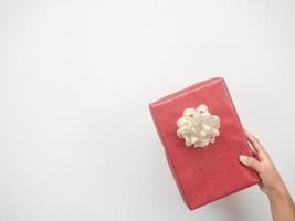 Woman hand holding red gift box on white background copy space photo