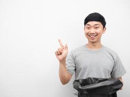 Man holding garbage smiling and point finger at copy space photo