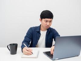 hombre que usa una computadora portátil en el escritorio lugar de trabajo emoción de trabajo seria foto