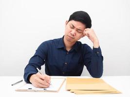 hombre asiático escribiendo en el tablero de documentos y sintiendo tensión fondo blanco foto