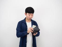 Asian man feeling amazed and shocked at face with a lot of money in his wallet on white background photo