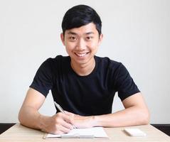 Asian man happy smile sit at desk with check list and mobile phone interview concept photo