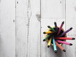 muchos círculos coloridos de pluma en caja sobre mesa de madera y luz natural del concepto de idea solar vista superior, negocios y educación foto