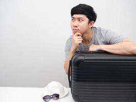 Man with luggage gesture gesture thinking with holiday looking at copy space photo