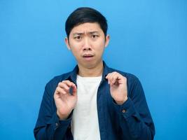 Asian man gesture scare and feeling afriad something blue background photo