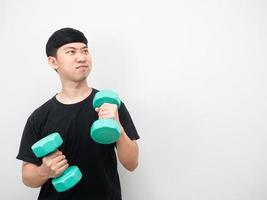 Asian man exercise with dumbbell feeling enjoy and looking at copy space photo