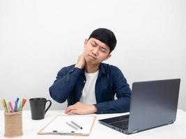 hombre asiático sentado en el lugar de trabajo de oficina concepto de síndrome de oficina de dolor de cuello foto