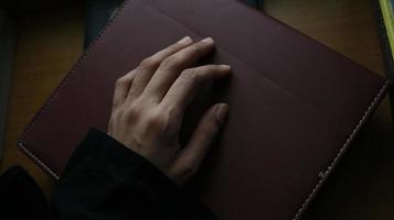 Closeup of a woman's hand on a book in a gloomy setting photo