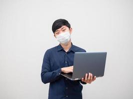 hombre enfermo con máscara usando una computadora portátil en su mano cara infeliz sobre fondo blanco foto