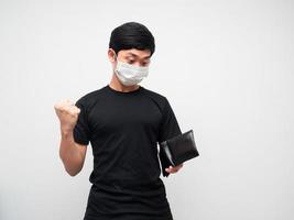 Portrait man wearing mask feeling happy show fist up while looking wallet in his hand on white background photo