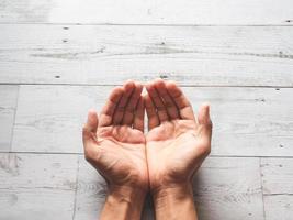 Closeup praying hands and sunlight nature shadow on wood table top view photo