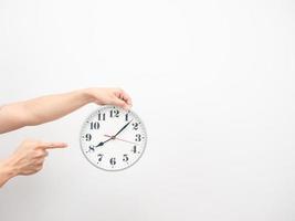 Hand point finger at analog clock copy space white isolated photo