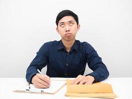 Man sitting at workplace feeling bored with document looking up white background photo