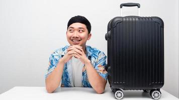 Man blue shirt with luggage smiling thinking about holiday trip photo