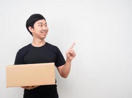 hombre que sostiene la caja de la compra y señala con el dedo el espacio de la copia foto