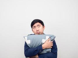 Asian man hug pillow feeling sleepy and bored looking up photo