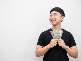 Asian man holding money dollar feeling happy looking and copy space photo