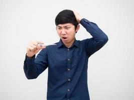 hombre asiático que se siente sorprendido mirando el termómetro en su mano retrato de fondo blanco foto